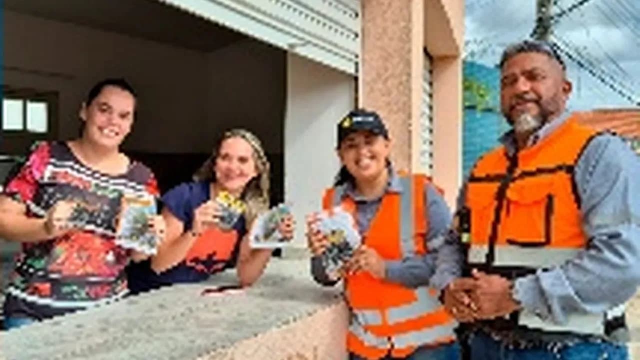 Colaboradores da Santin com coletes laranja entregam material de campanha de conscientização em Pedra Lavrada (PB)