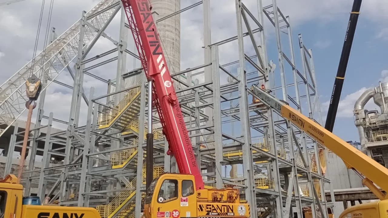 Guindaste Sany vermelho operando ao lado da estrutura metálica da caldeira da CMPC